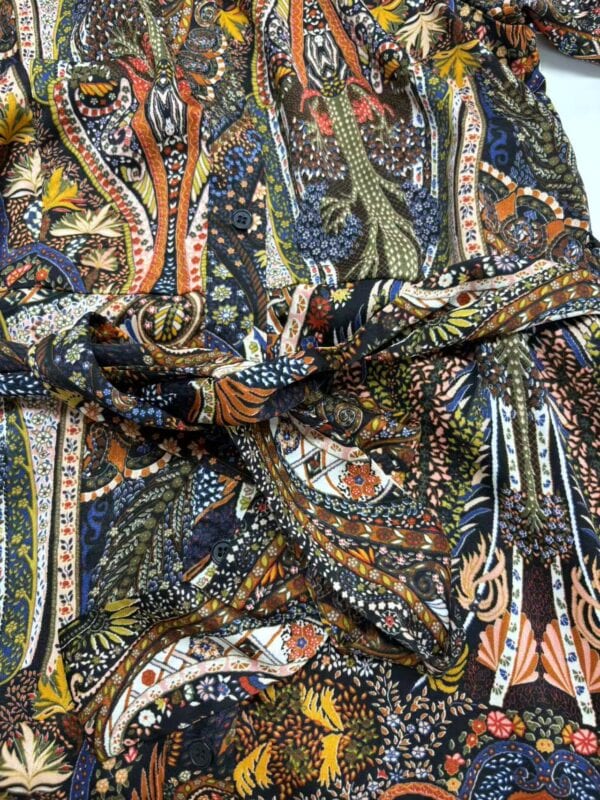 Close-up of vibrant, intricate bohemian fabric with floral and paisley designs in multiple colors.