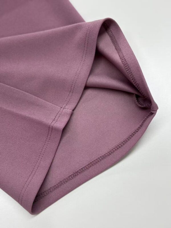 Close-up of pink sports leggings showing smooth fabric and stitched seams, ideal for activewear and fitness enthusiasts.