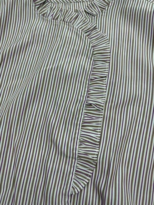 Close-up of striped fabric with ruffle detail, showcasing fine stitching and pattern, ideal for fashion and clothing design.