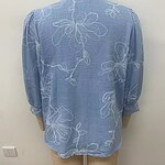 Light blue women's blouse with white floral embroidery, long sleeves, and a relaxed fit, perfect for casual or semi-formal occasions.