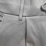 Close-up of stylish grey men's trousers showing waistband and fabric texture, ideal for formal or business casual wear.