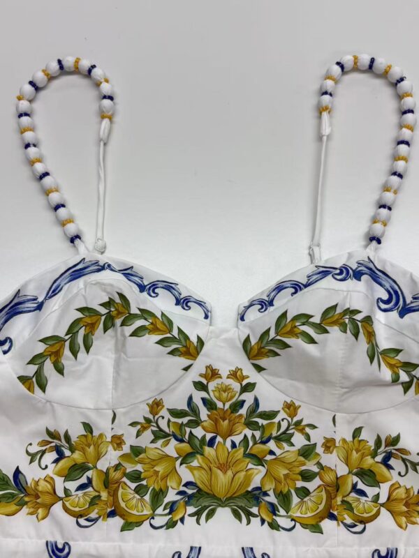 Colorful embroidered dress with floral patterns and beaded straps, showcasing traditional craftsmanship and vibrant design.
