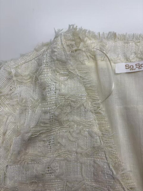 Close-up of intricate lace fabric with delicate embroidery, suitable for high-end fashion and couture clothing.