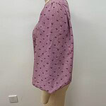 Pink women's blouse with small heart patterns, featuring a round neckline and puffed sleeves, displayed on a mannequin.