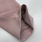 Close-up of blush pink fabric with smooth texture and folded design, showcasing high-quality material and craftsmanship.
