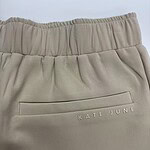 Close-up of beige casual joggers with elastic waistband and back pocket featuring 'KATE JUNE' branding, perfect for comfortable everyday wear.