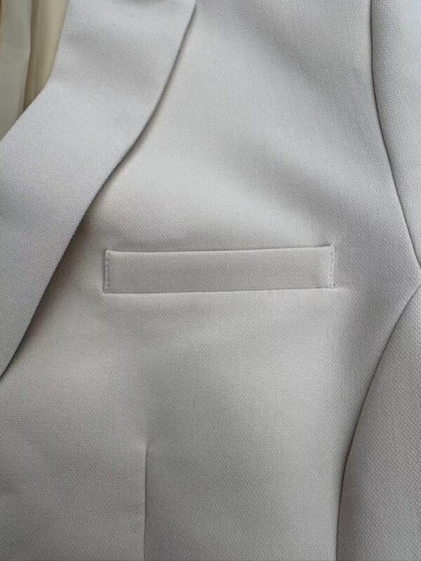 Close-up of a light grey blazer with a sleek pocket design, perfect for formal or business attire, showcasing high-quality fabric and craftsmanship.