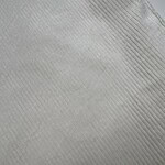 Close-up of white fabric with fine ribbed texture, ideal for fashion design and textile projects.