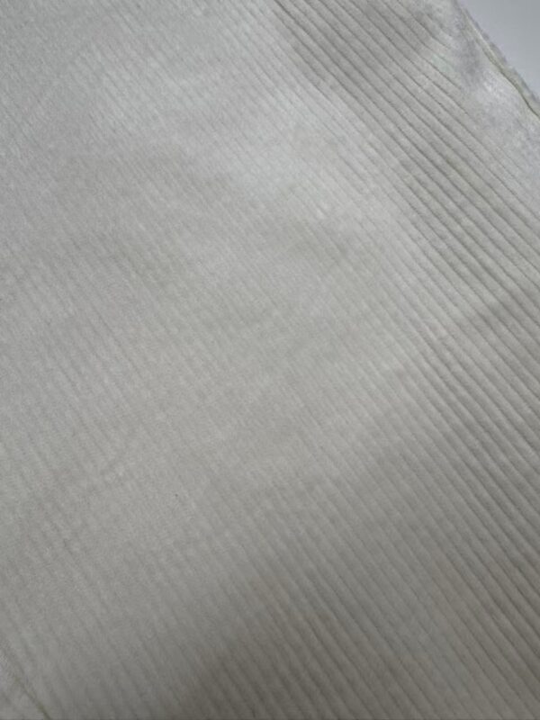 Close-up of white fabric with fine ribbed texture, ideal for fashion design and textile projects.