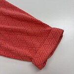 Close-up of a red textured fabric with geometric pattern, ideal for fashion and clothing design.