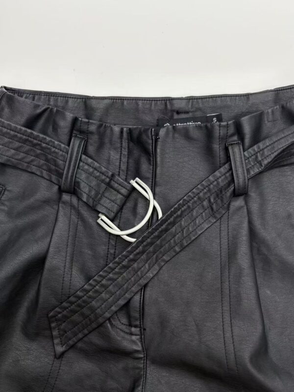 Close-up of stylish men's black leather pants with a belt and zipper, suitable for fashion and casual wear.