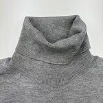 Close-up of a gray turtleneck sweater, showcasing the soft knit fabric and high collar design, ideal for fall and winter fashion.