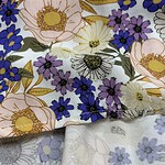 Close-up of floral fabric with pink, purple, white, and yellow flowers, suitable for fashion and textile projects.