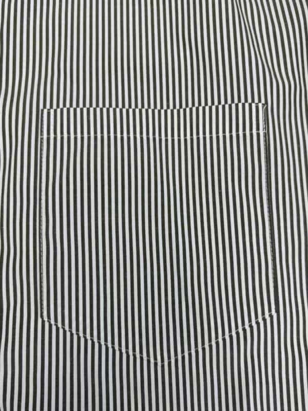 Close-up of a black and white vertically striped shirt with a single chest pocket.