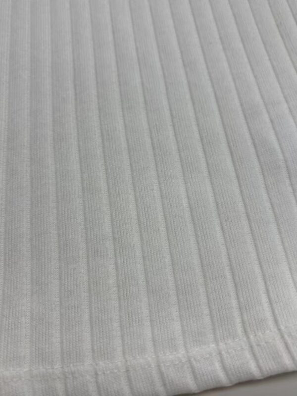 Close-up of light gray ribbed fabric texture, ideal for clothing and fashion design, showing fine vertical lines and soft material.