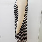 Side view of a sleeveless black and white zigzag patterned dress on a mannequin, showcasing a stylish and modern design.