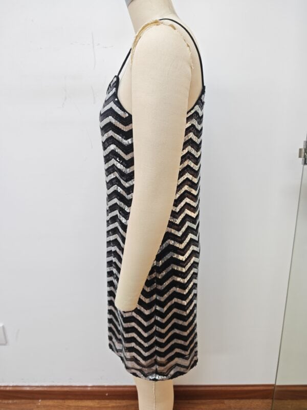 Side view of a sleeveless black and white zigzag patterned dress on a mannequin, showcasing a stylish and modern design.