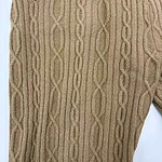Close-up of beige cable knit sweater pants with intricate pattern and drawstring waist, perfect for casual winter wear.