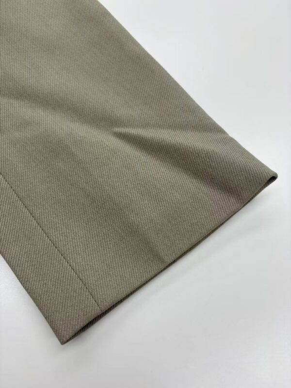 Close-up of khaki fabric with a smooth texture, suitable for clothing and fashion accessories.
