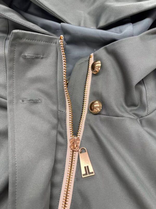Close-up of stylish grey pants featuring a gold zipper and buttons, showcasing high-quality fabric and modern design for fashion-forward individuals.