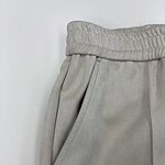 Close-up of grey sweatpants with elastic waistband and side pocket, suitable for casual wear and loungewear.