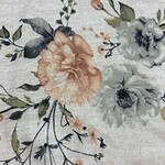Close-up of floral fabric with peach, white, and gray flowers and green leaves, ideal for fashion and textile projects.