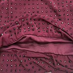 Close-up of burgundy fabric adorned with small rhinestones, showcasing a luxurious and stylish material suitable for fashion apparel and accessories.