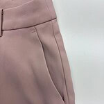 Close-up of stylish pink women's trousers with tailored fit and clean stitching, perfect for casual or office wear.