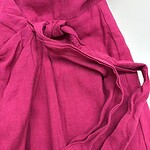 Close-up of a vibrant pink lounge robe made of soft fabric with a tied waist and pockets, perfect for comfortable home wear.