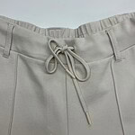 Close-up of beige casual pants with drawstring waist, suitable for everyday wear and comfortable fashion.