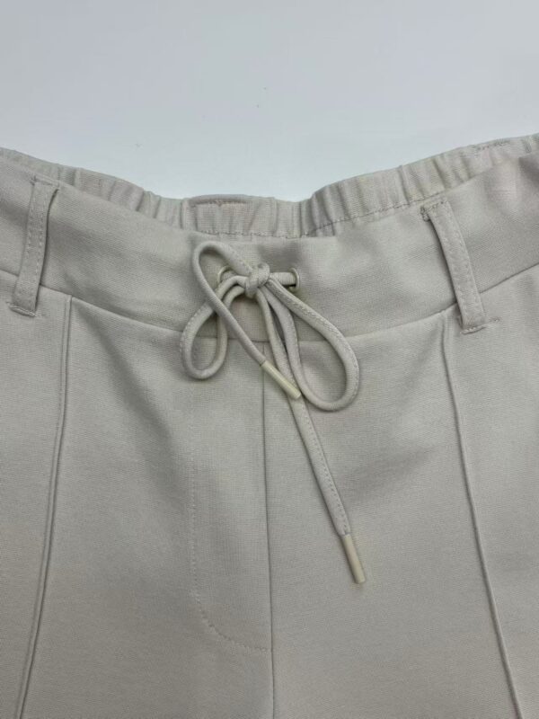 Close-up of beige casual pants with drawstring waist, suitable for everyday wear and comfortable fashion.
