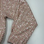 Close-up of a pink blazer adorned with shiny sequins, showcasing a stylish and glamorous look for women.