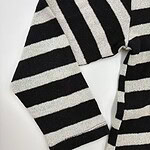 Close-up of a black and white striped sweater, showcasing the fabric texture and pattern, ideal for casual or stylish winter wear.