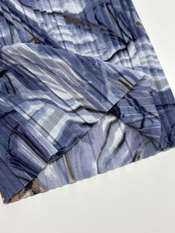 Close-up of blue plaid fabric with various shades of blue, gray, and brown, showcasing a soft, lightweight material suitable for clothing or accessories.