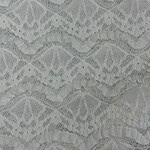 Close-up of intricate white lace fabric showcasing detailed floral and geometric patterns, ideal for fashion and bridal wear.