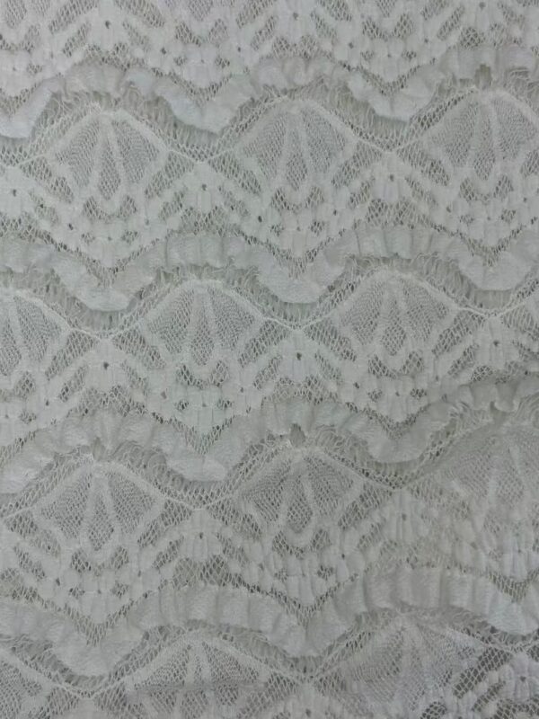 Close-up of intricate white lace fabric showcasing detailed floral and geometric patterns, ideal for fashion and bridal wear.