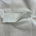 Close-up of a light grey fashion jacket featuring a zipper pocket and soft fabric texture, ideal for stylish casual wear.