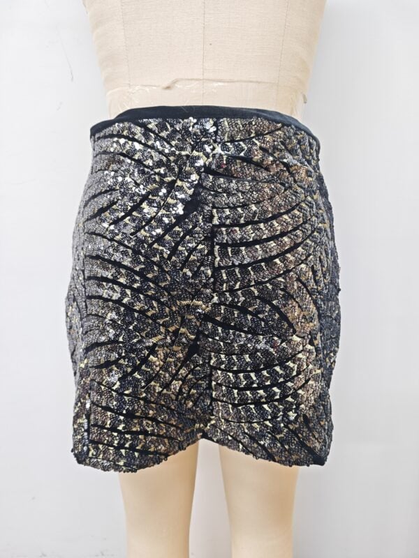 Shimmering black and gold sequin mini skirt with intricate pattern, perfect for parties and special occasions.