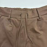 Close-up of brown casual jogger pants with elastic waistband and drawstring, suitable for comfortable everyday wear.