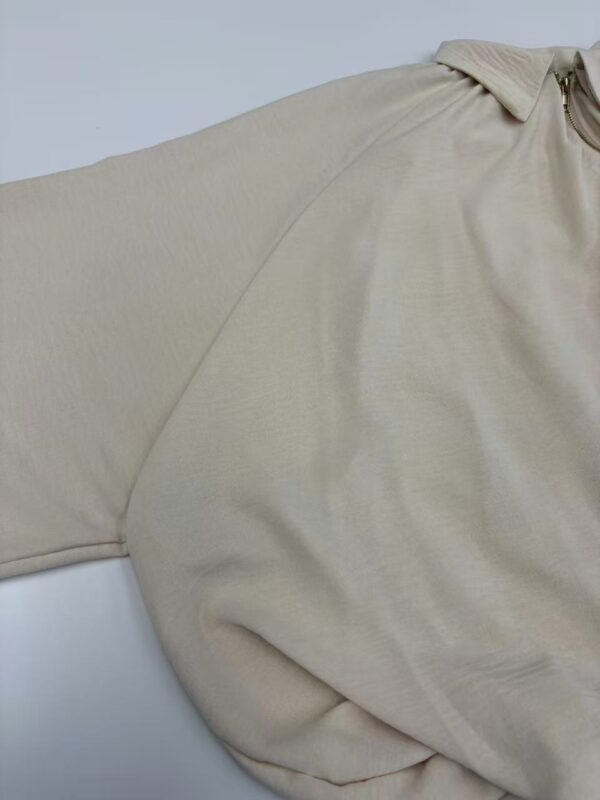 Close-up of a beige casual polo shirt made from soft fabric, featuring a collar and short sleeves, suitable for everyday wear.