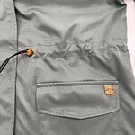 Close-up of a grey backpack with a front pocket and adjustable drawstring, perfect for casual or outdoor use.
