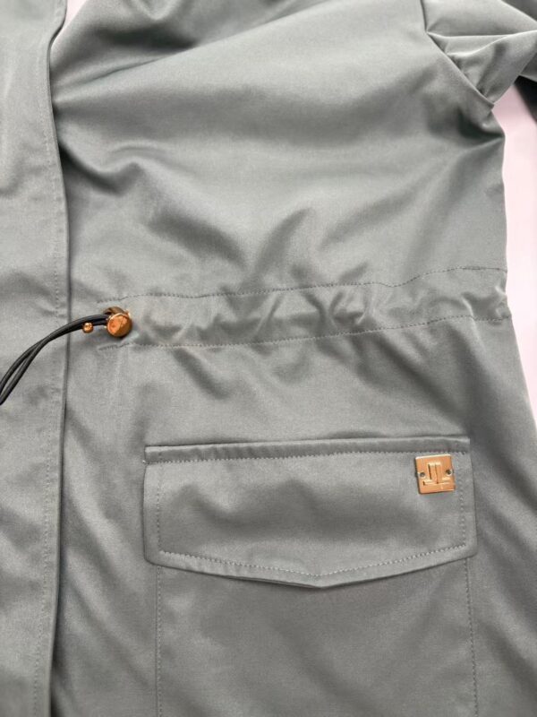 Close-up of a grey backpack with a front pocket and adjustable drawstring, perfect for casual or outdoor use.