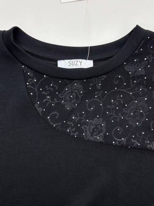 Close-up of a black dress featuring a round neckline with intricate floral embroidery and sparkling embellishments for a sophisticated look.