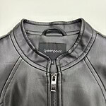 Close-up of a stylish black leather jacket with a silver zipper and round neckline, perfect for men's fashion and casual wear.