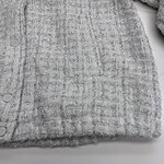 Close-up of a grey textured fabric with a subtle checkered pattern, perfect for fashion or home decor applications.