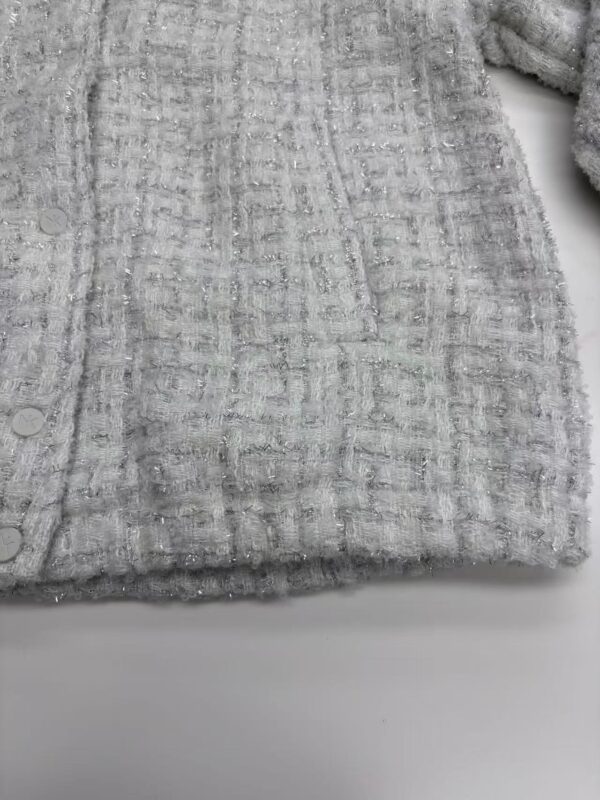 Close-up of a grey textured fabric with a subtle checkered pattern, perfect for fashion or home decor applications.