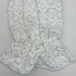 Close-up of a white lace dress with intricate floral patterns and ruffled details, perfect for special occasions or summer events.