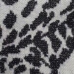 Close-up of leopard print fabric with black spots on a light background, showcasing textured material suitable for stylish clothing and accessories.