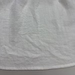 Close-up of white fabric material showing texture and slight wrinkles, ideal for fashion or textile product images.