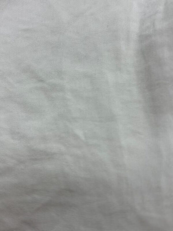 Close-up of plain white fabric background, suitable for fashion and clothing product displays.